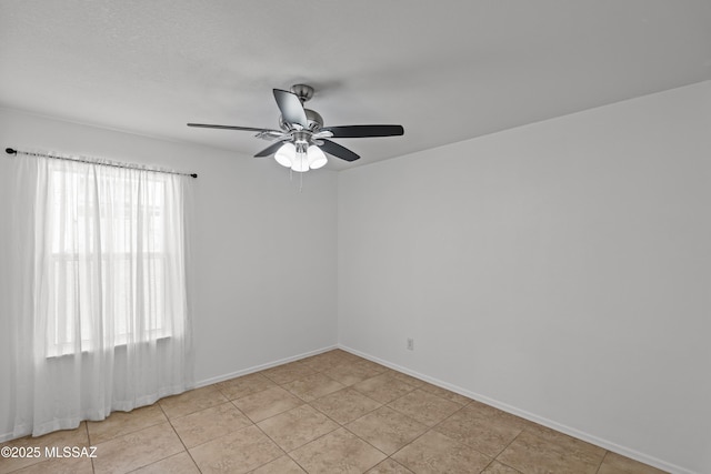 6945 S Wingbow Dr, Tucson, AZ 85756 - spare room featuring healthy amount of natural light, ceiling fan, light tile patterned floors, and baseboards