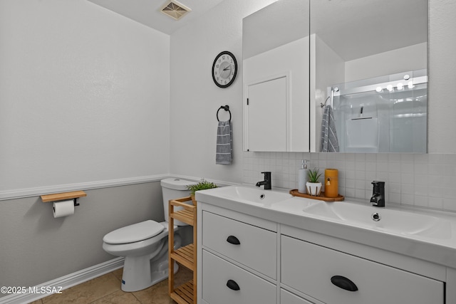 6945 S Wingbow Dr, Tucson, AZ 85756 - bathroom with toilet, double vanity, a shower with door, decorative backsplash, and tile patterned floors