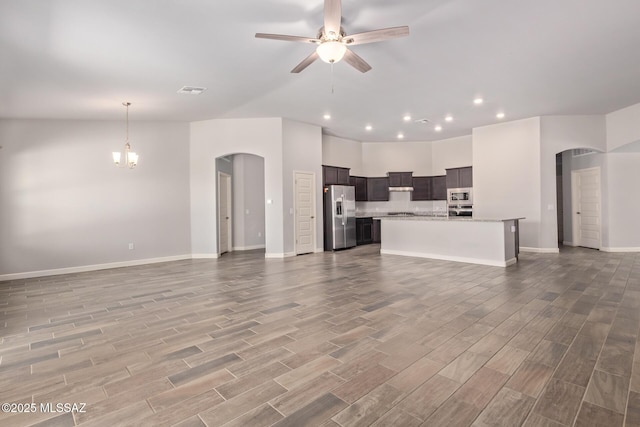 854 S Willis Ave, Vail, AZ 85641 - unfurnished living room featuring arched walkways, recessed lighting, baseboards, and wood finished floors
