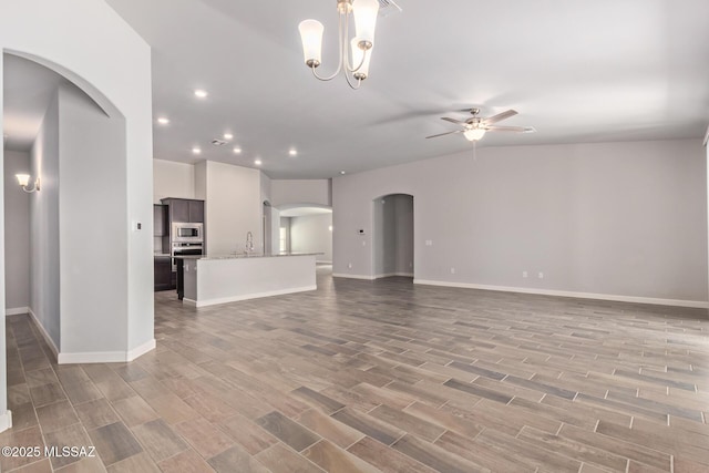 854 S Willis Ave, Vail, AZ 85641 - unfurnished living room featuring ceiling fan, light wood-style flooring, arched walkways, recessed lighting, and baseboards