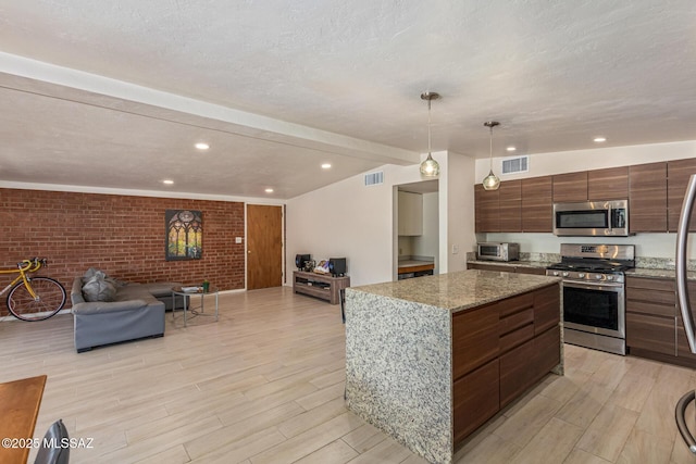 5809 E Rosewood St, Tucson, AZ 85711 - kitchen featuring appliances with stainless steel finishes, open floor plan, modern cabinets, a kitchen island, and light wood-style flooring