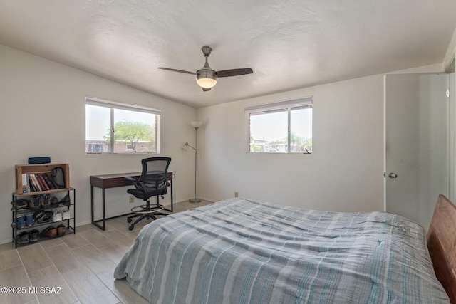 5809 E Rosewood St, Tucson, AZ 85711 - bedroom featuring multiple windows, wood tiled floors, a ceiling fan, and baseboards