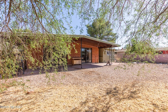 5809 E Rosewood St, Tucson, AZ 85711 - rear view of property featuring a patio and brick siding