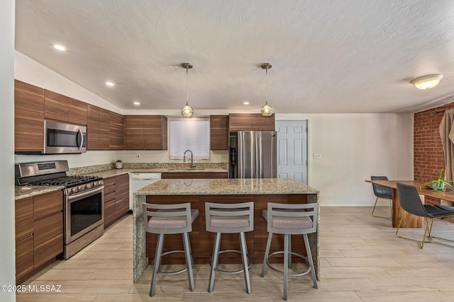 5809 E Rosewood St, Tucson, AZ 85711 - kitchen featuring stainless steel appliances, a sink, wood finish floors, a kitchen breakfast bar, and recessed lighting
