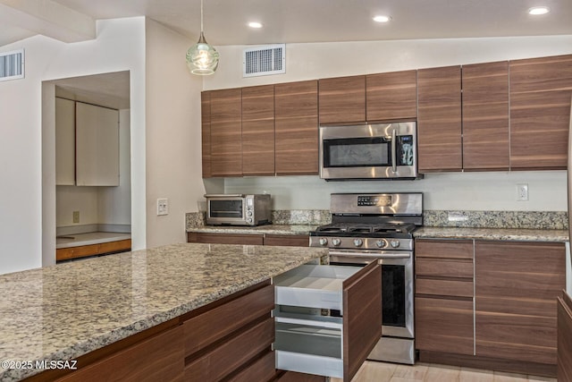 5809 E Rosewood St, Tucson, AZ 85711 - kitchen featuring stainless steel appliances, light stone counters, hanging light fixtures, recessed lighting, and modern cabinets