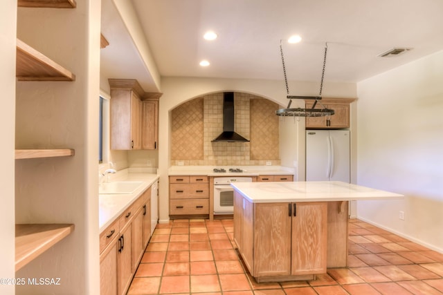 7275 E Vuelta Rancho Mesquite, Tucson, AZ 85715 - kitchen featuring wall chimney exhaust hood, a sink, light brown cabinetry, white appliances, and tasteful backsplash