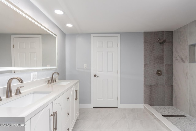 7909 E Beverly St, Tucson, AZ 85710 - bathroom featuring tiled shower, double vanity, baseboards, and recessed lighting