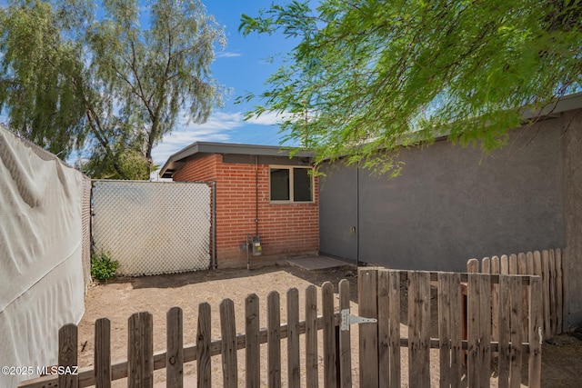 7909 E Beverly St, Tucson, AZ 85710 - view of home's exterior with brick siding and a gate