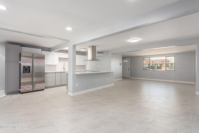 7909 E Beverly St, Tucson, AZ 85710 - kitchen with stainless steel refrigerator with ice dispenser, range hood, open floor plan, light countertops, and baseboards