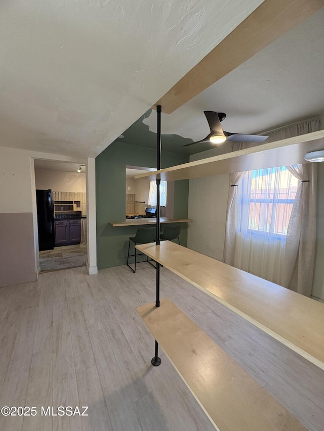 140 W 27th St, Tucson, AZ 85713 - below grade area with freestanding refrigerator, a ceiling fan, and wood finished floors