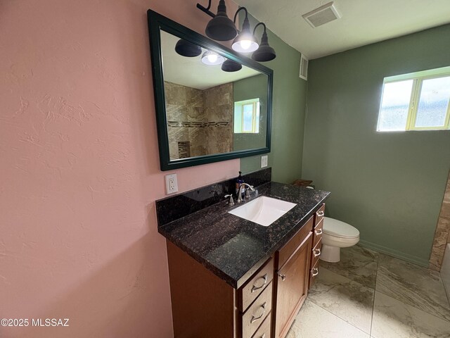 140 W 27th St, Tucson, AZ 85713 - bathroom featuring vanity, toilet, marble finish floors, and a tile shower