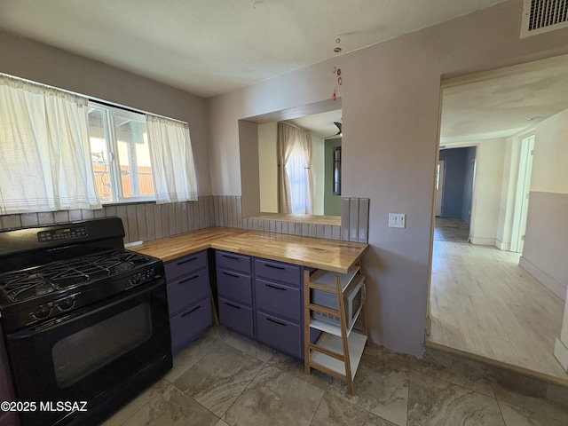140 W 27th St, Tucson, AZ 85713 - kitchen featuring black gas range, wood counters, and blue cabinets