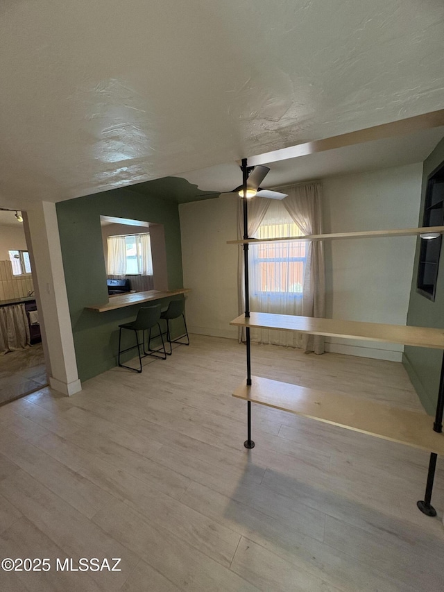 140 W 27th St, Tucson, AZ 85713 - below grade area featuring ceiling fan, wood finished floors, and baseboards
