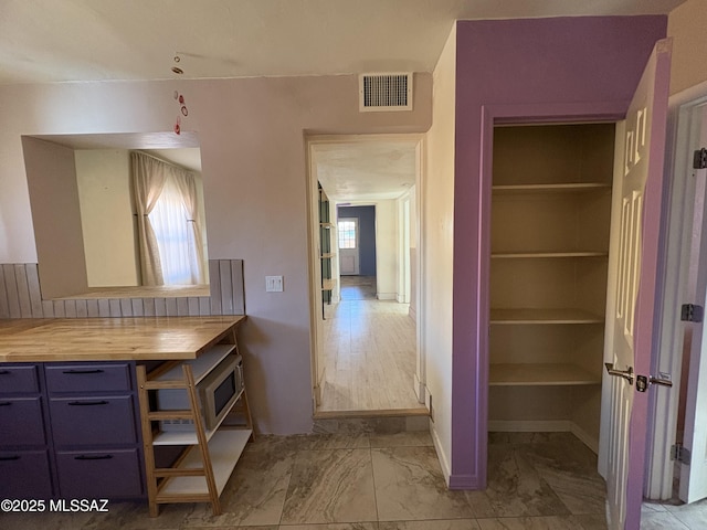 140 W 27th St, Tucson, AZ 85713 - interior space featuring wooden counters, blue cabinets, light marble finish flooring, and baseboards