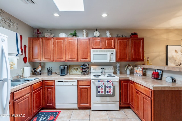 6255 N Camino Pimeria Alta Unit 22, Tucson, AZ 85718 - kitchen with white appliances, a sink, light tile patterned floors, a skylight, and recessed lighting