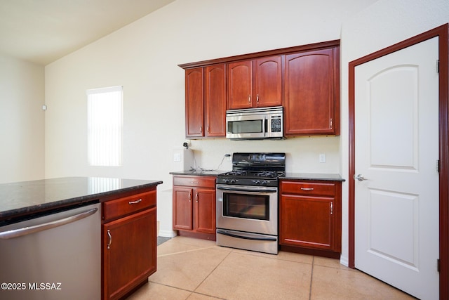 4210 S Santolina Ct, Sierra Vista, AZ 85650 - kitchen featuring appliances with stainless steel finishes, dark brown cabinets, light tile patterned floors, dark stone countertops, and lofted ceiling
