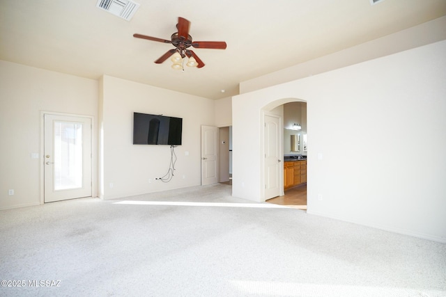 4210 S Santolina Ct, Sierra Vista, AZ 85650 - unfurnished living room featuring light carpet, arched walkways, a ceiling fan, and baseboards