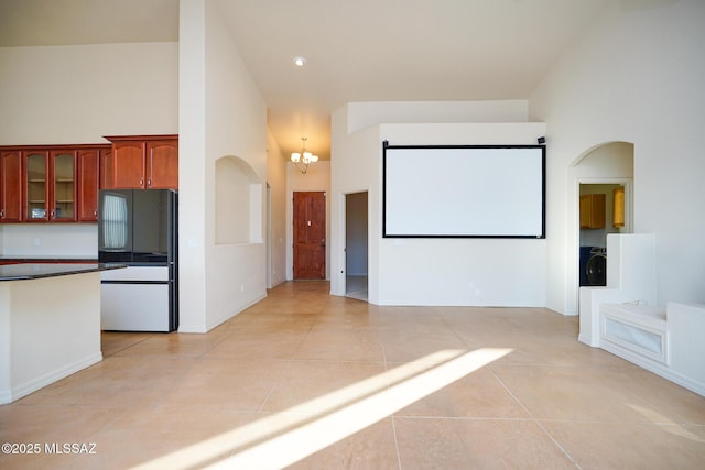 4210 S Santolina Ct, Sierra Vista, AZ 85650 - cinema room with a chandelier, light tile patterned floors, a towering ceiling, arched walkways, and baseboards