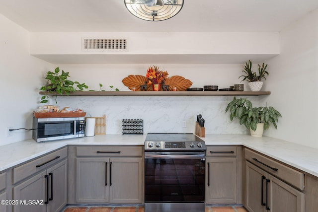 9845 N Volk Ave, Marana, AZ 85653 - kitchen featuring appliances with stainless steel finishes, open shelves, gray cabinets, and light stone counters
