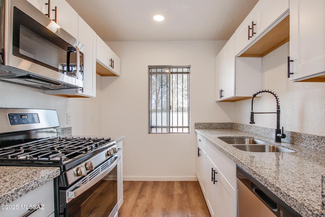 828 S Langley Ave Unit 101, Tucson, AZ 85710 - kitchen with stainless steel appliances, a sink, light wood-type flooring, baseboards, and light stone countertops