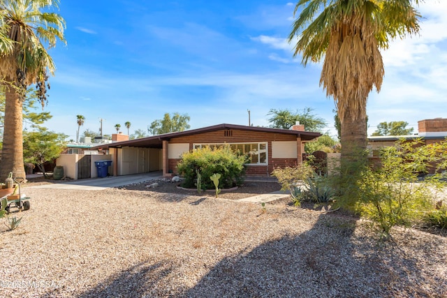 5826 E Hawthorne St, Tucson, AZ 85711 - view of front of house with concrete driveway, an attached carport, and a chimney