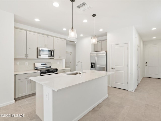 13097 N Farmhouse Ln, Marana, AZ 85653 - kitchen with stainless steel appliances, a sink, recessed lighting, light countertops, and a kitchen island with sink