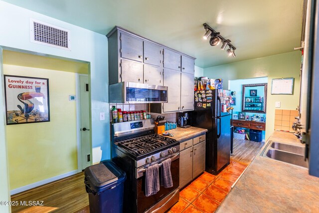 453 W Union St, Benson, AZ 85602 - kitchen with appliances with stainless steel finishes, light countertops, a sink, light wood finished floors, and backsplash