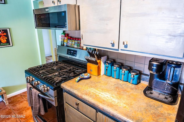 453 W Union St, Benson, AZ 85602 - kitchen with stainless steel appliances, baseboards, tile patterned flooring, light countertops, and backsplash
