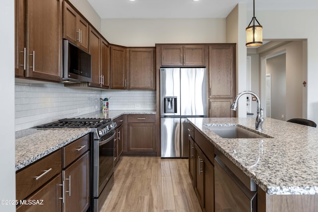 62146 E Marble Dr, Oracle, AZ 85623 - kitchen with appliances with stainless steel finishes, a sink, light stone countertops, decorative light fixtures, and recessed lighting
