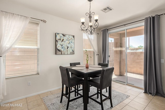7952 E Revolution Loop, Tucson, AZ 85730 - dining room featuring light tile patterned flooring, healthy amount of natural light, a chandelier, and baseboards