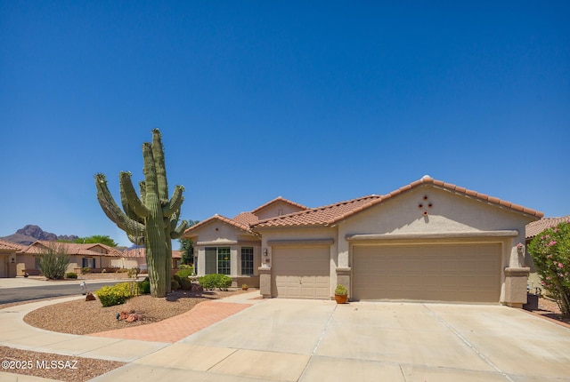 9345 N Cottage Garden Pl, Tucson, AZ 85743 - mediterranean / spanish home with stucco siding, an attached garage, concrete driveway, and a tiled roof