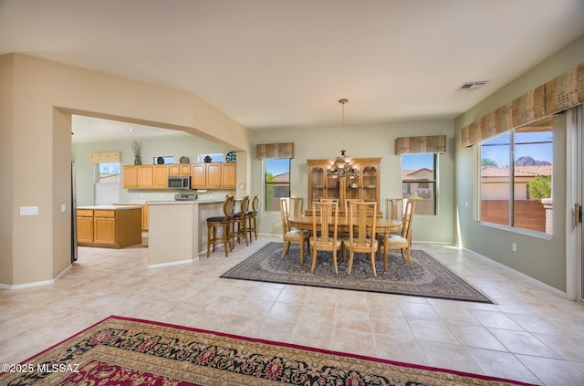 9345 N Cottage Garden Pl, Tucson, AZ 85743 - dining space featuring plenty of natural light, light tile patterned floors, a chandelier, and baseboards