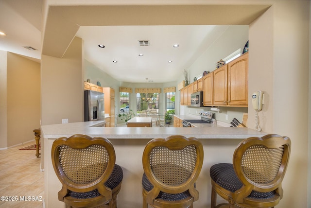 9345 N Cottage Garden Pl, Tucson, AZ 85743 - kitchen featuring appliances with stainless steel finishes, a breakfast bar, recessed lighting, light countertops, and light tile patterned floors