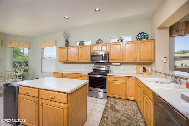 9345 N Cottage Garden Pl, Tucson, AZ 85743 - kitchen featuring appliances with stainless steel finishes, a sink, light countertops, light tile patterned floors, and a kitchen island