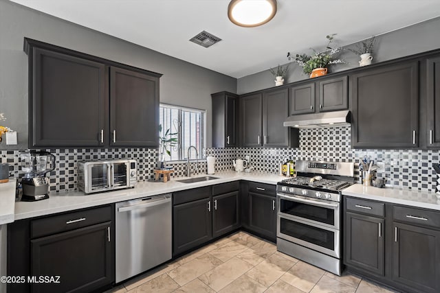 3630 W Center Mountain Way, Tucson, AZ 85746 - kitchen featuring appliances with stainless steel finishes, under cabinet range hood, light marble finish flooring, and light countertops