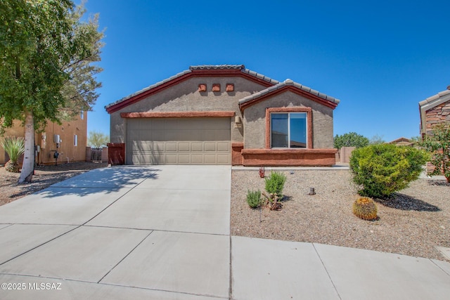 8068 S Nautilus Dr, Tucson, AZ 85756 - mediterranean / spanish-style home featuring an attached garage, driveway, a tile roof, and stucco siding