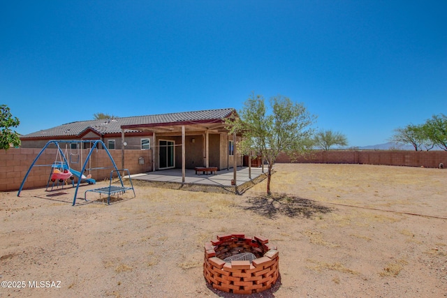 8068 S Nautilus Dr, Tucson, AZ 85756 - rear view of property with a playground, a patio area, a fenced backyard, and an outdoor fire pit