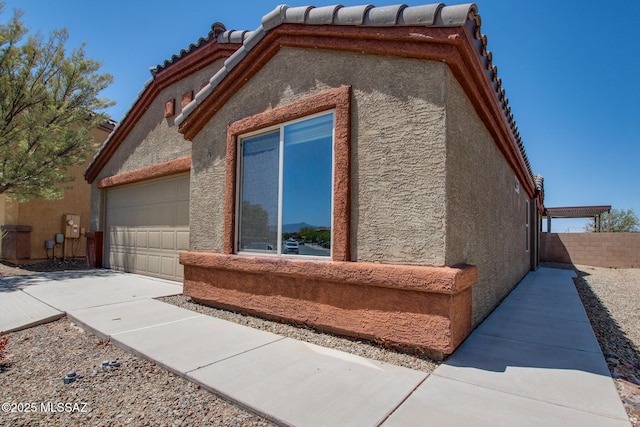 8068 S Nautilus Dr, Tucson, AZ 85756 - view of side of property featuring stucco siding, an attached garage, and a tile roof