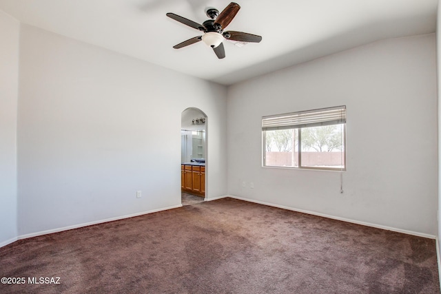 8068 S Nautilus Dr, Tucson, AZ 85756 - spare room with carpet, arched walkways, a ceiling fan, and baseboards