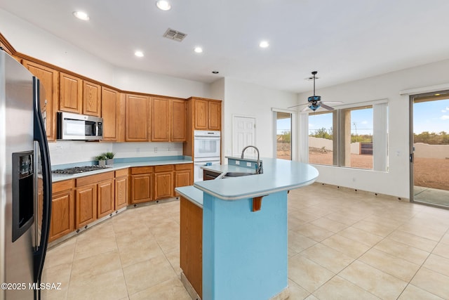 35 N Monument Estates Pl, Tucson, AZ 85748 - kitchen with stainless steel appliances, a sink, brown cabinets, an island with sink, and recessed lighting