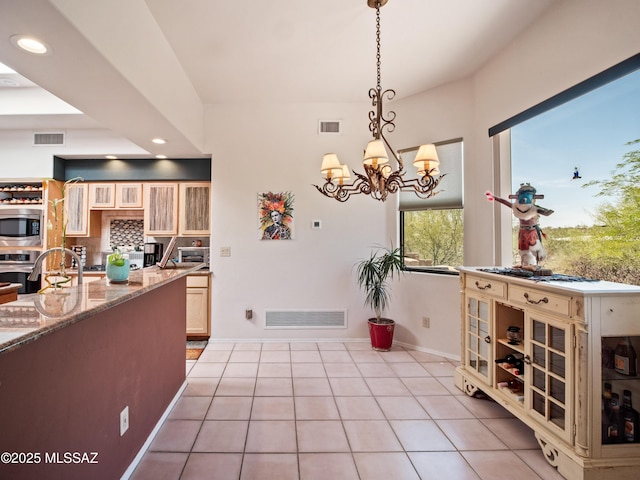 5475 E Placita De Royale, Tucson, AZ 85718 - kitchen featuring stainless steel appliances, light tile patterned floors, recessed lighting, light stone counters, and a chandelier