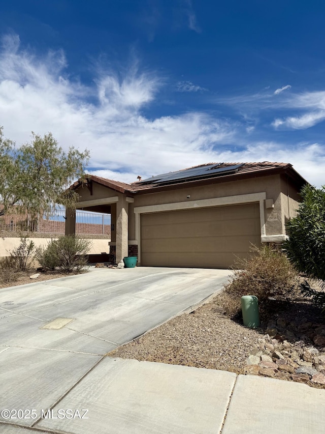 16038 S Camino Casal, Sahuarita, AZ 85629 - view of front of home featuring a garage, solar panels, stucco siding, and concrete driveway