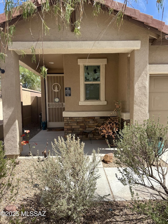 16038 S Camino Casal, Sahuarita, AZ 85629 - view of exterior entry featuring stucco siding, covered porch, and stone siding