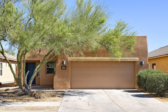 10393 Yew Pl, Tucson, AZ 85747 - view of front of home featuring concrete driveway, stucco siding, and a garage