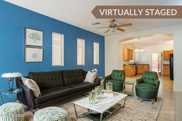 10393 Yew Pl, Tucson, AZ 85747 - living area featuring light tile patterned floors, a chandelier, arched walkways, and a ceiling fan