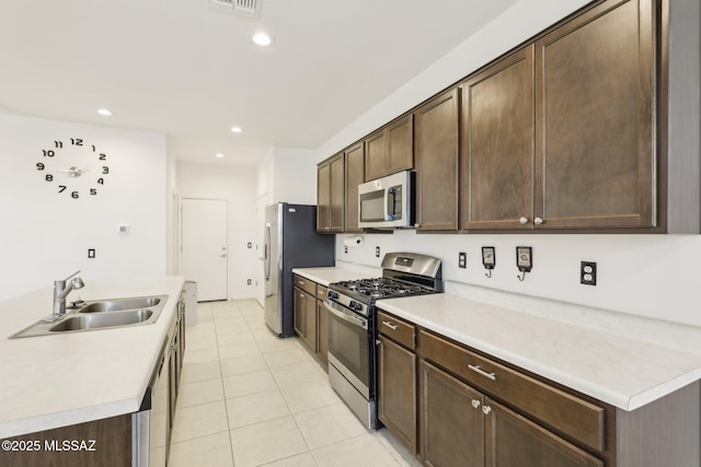 22039 E Thunderhead Dr, Red Rock, AZ 85145 - kitchen featuring stainless steel appliances, a sink, dark brown cabinets, light tile patterned floors, and recessed lighting
