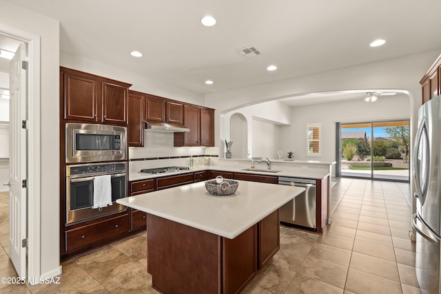 61050 E Amur Ln, Oracle, AZ 85623 - kitchen featuring appliances with stainless steel finishes, a sink, arched walkways, light countertops, and recessed lighting