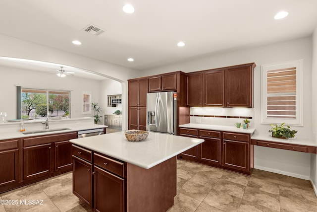 61050 E Amur Ln, Oracle, AZ 85623 - kitchen with stainless steel fridge, a sink, light countertops, arched walkways, and recessed lighting