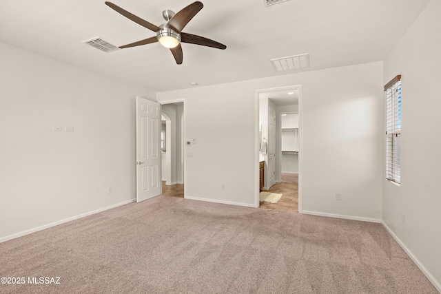61050 E Amur Ln, Oracle, AZ 85623 - unfurnished bedroom featuring light carpet, baseboards, a ceiling fan, and a spacious closet