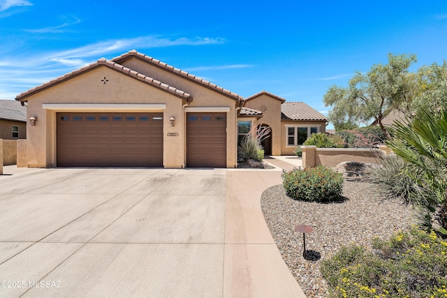 61050 E Amur Ln, Oracle, AZ 85623 - mediterranean / spanish-style home featuring stucco siding, an attached garage, concrete driveway, and a tiled roof